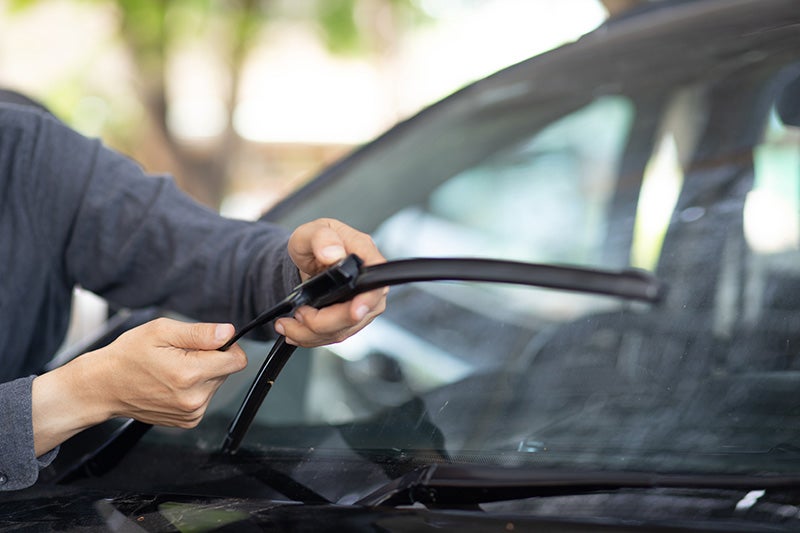 Person checking their car's windshield wipers